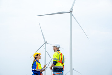 Engineer inspection and survey work in wind turbine farms rotation to generate electricity energy.