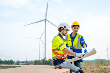 Group of engineers are working with a blueprint in wind turbine farm,Wind power station,Renewable and clean energy concept.
