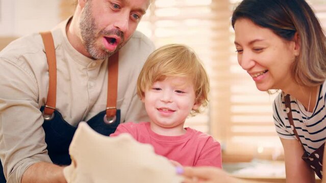 Caucasian attractive couple baking bakery with son in kitchen at home.