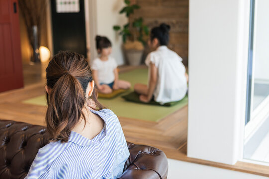 和室で遊ぶ姉妹と見守る母親