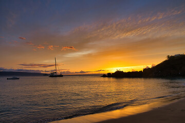 Fototapeta na wymiar Boat just off shore at Black Rock on Maui at sunset
