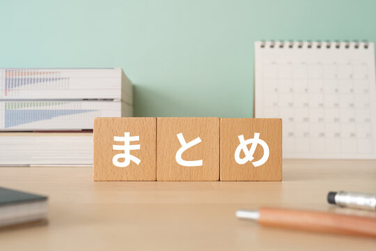 まとめのイメージ｜まとめと書かれたブロックが置かれたデスク