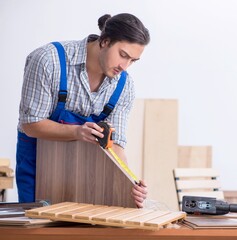 Young male carpenter working indoors