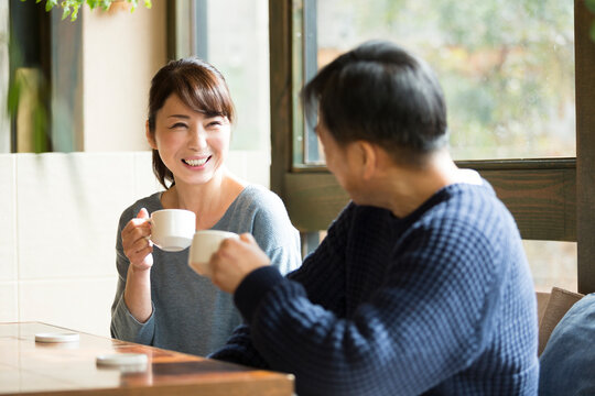 カフェでコーヒーを飲みながら談笑する夫婦