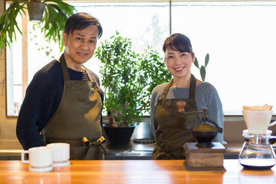 カフェのカウンターに立つ夫婦