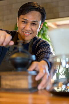 コーヒー豆を挽く男性