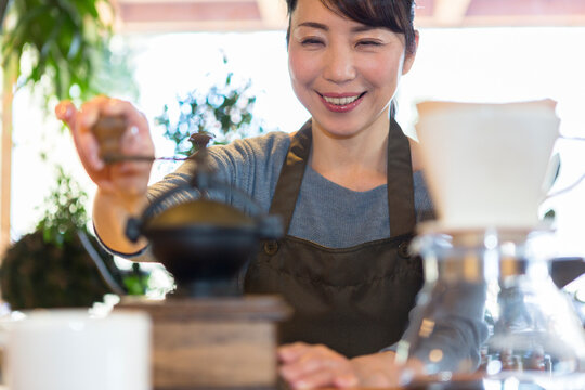 コーヒー豆を挽く女性