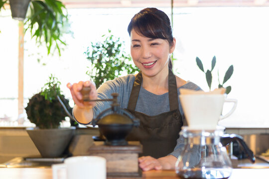 コーヒー豆を挽く女性