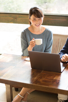 カフェでコーヒーを飲みながら談笑する夫婦