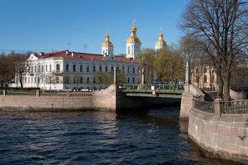 Obraz premium View of the Krasnogvardeysky Bridge over the Griboyedov Canal and the dome of the St. Nicholas Naval Cathedral on a sunny spring day, St. Petersburg, Russia