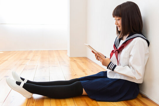 床に座って読書する女子中学生