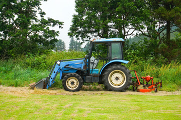 Obraz premium Tractor machine stopped in a green field