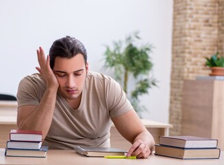 Young male student preparing for exams at library