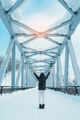 Woman tourist Visiting in Biei, Traveler in Sweater sightseeing Shirahige Waterfall bridge with Snow in winter. landmark and popular for attractions in Hokkaido, Japan. Travel and Vacation concept