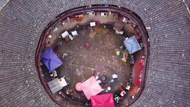 Bird's Eye Aerial Pull Away shot of a Unesco World Heritage Tulou Hakka with traditional architecture and layout, Fujian, China