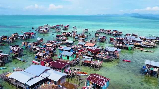 Amazing flyover sea houses of Bajau Laut, water village with sunlight in Sabah, Borneo, Omadal Island, Malaysia