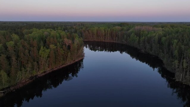 Flight over the calm, smooth Tündre lake shortly after sunset in spring. Estonia.