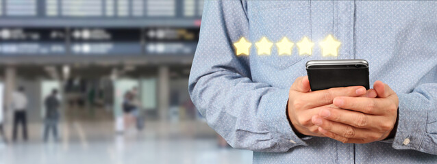 Man holding smartphone device and touching screen with five star rating