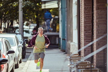Middle aged latin man jogging in the city