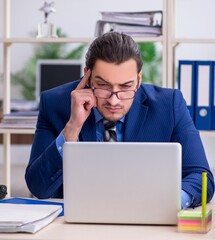 Young businessman employee unhappy with excessive work