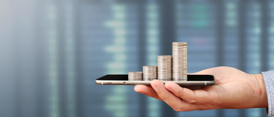 Hand holding smartphone device and touching screen. Stock exchange market concept. looking