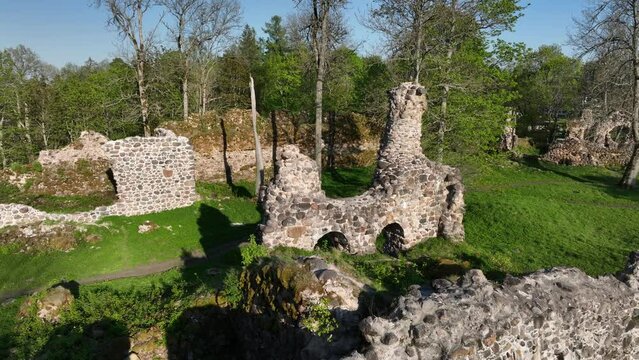 Panning aerial of ruins of Helme Order Castle on a sunny evening. Estonia.