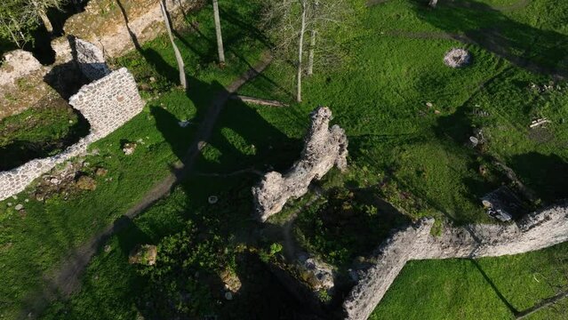 Approaching aerial drone view of Helme Order Castle with strong shadows on a sunny evening, Estonia.