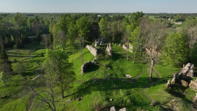 Approaching aerial view of Helme Order Castle with strong shadows on a sunny evening, Estonia.