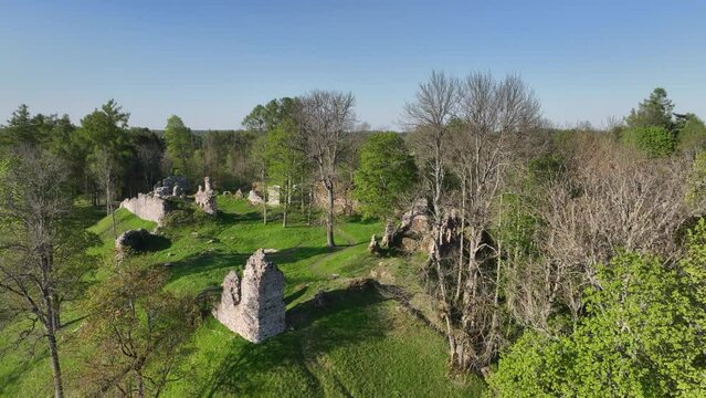 Approaching aerial drone view of Helme Order Castle on a sunny evening. Estonia.