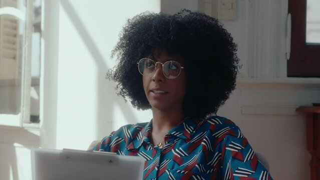 Black Female Therapist Sitting With Clipboard, Speaking And Answering Questions During Counseling Session, Consulting Patient. Medium Close-up Shot