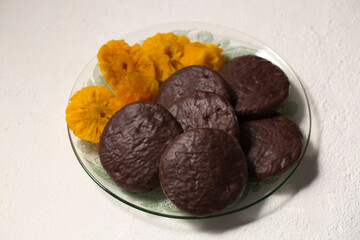 Round cookies in chocolate with cinnamon and candied pineapple