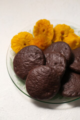 cookies in chocolate with cinnamon and candied pineapple, close-up