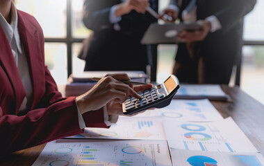Close-up of businesswoman hands using a calculator to check company finances and earnings and budget. Business woman calculating monthly expenses, managing budget, papers, loan documents, invoices.