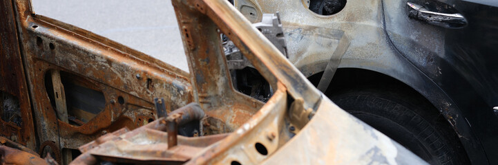 Burnt old rusty cars in parking closeup. Transport insurance against fire concept