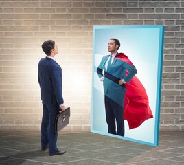 Businessman seeing himself in mirror as superhero © Elnur