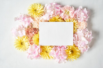 white card for text. Petals of flowers, carnation, gerbera, hydrangea, rose. Valentine's day romantic background . Space for words. Love letter. 