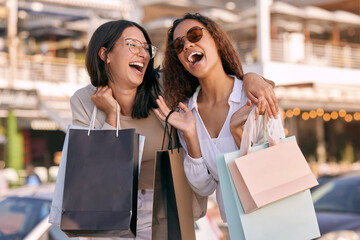 Happy, women friends with shopping bags and at street in city with a smile. Promotion or discount,...