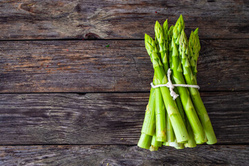 Bunch of green asparagus on wooden background
