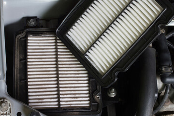 Replacing the car's air filter. Old and new air filters in the engine compartment of the car.