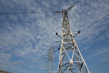 High-voltage power lines at sunset. Electricity distribution station. Electricity pylons on the background of the sky.
