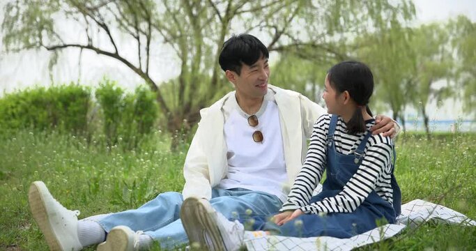 피크닉 담요를 펴고 앉아 쉬고있는 아빠와 아이 