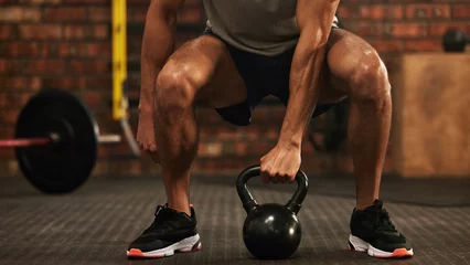 Papier Peint photo Fitness Sports, kettlebell and male athlete doing a workout in the gym for strength, health and motivation. Fitness, strong and closeup of a man doing an arm exercise with weights and squats in sport center.
