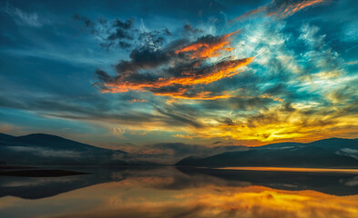 Unique cloud shape sunset over mountain lake - 609831612