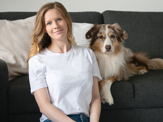 Frau mit Hund Australian Shepherd weißes T-Shirt Jeans Mockup Indoor Sofa Zuhause Kissen Couch