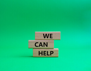 We can help symbol. Wooden blocks with words We can help. Beautiful green background. Business and...
