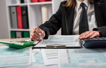 Woman wear black clasik suit filling 1040 blank US tax form
