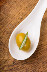 Olive oil and olive branch on table