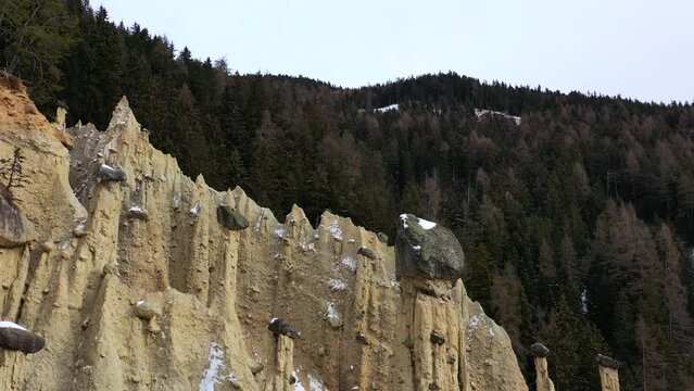 Aerial view passing stone pillars at the Earth Pyramids a natural phenomena of cloudy South Tyrol