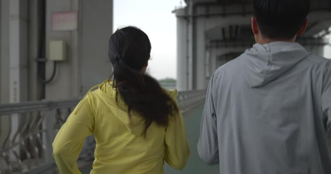 한강다리를 달리며 운동하는 부부의 뒷모습 