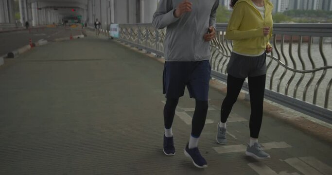 한강다리를 달리며 운동하는 부부 